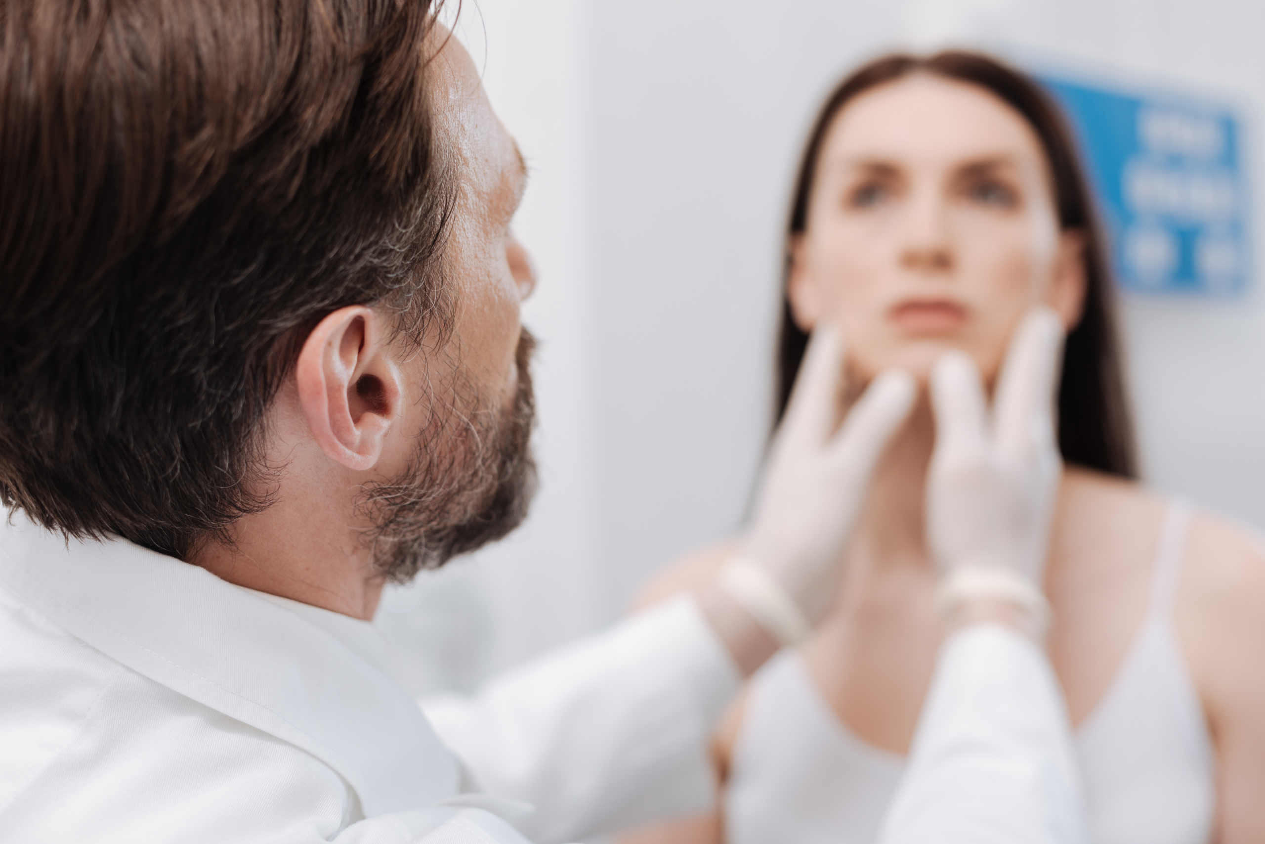 plastic surgeon examining patients face